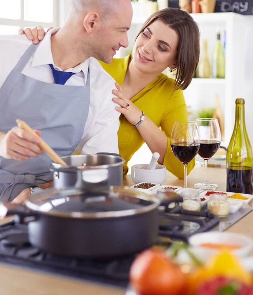 Atractiva pareja enamorada de cocinar y abre el vino en la cocina mientras cocinan la cena para una velada romántica —  Fotos de Stock