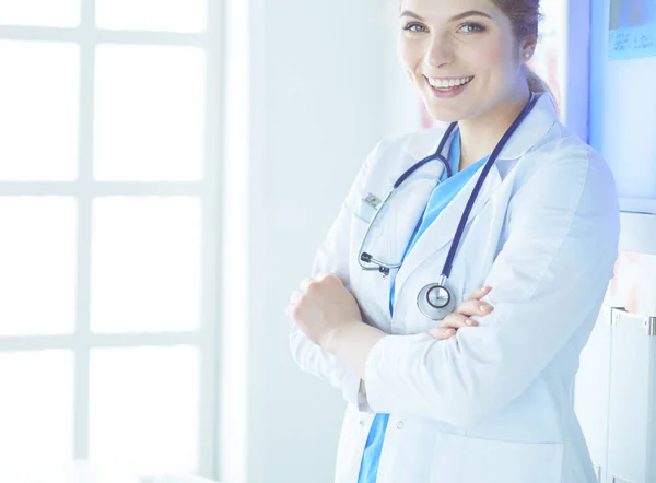 Молода жінка-лікар в білій формі стоїть в офісі клінік — стокове фото