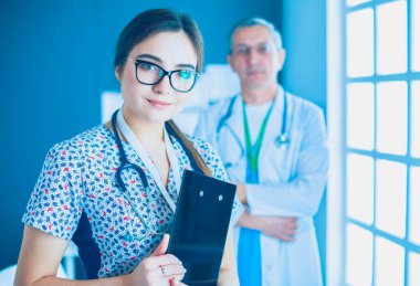 Bir doktor ekibi, kadın ve erkek, ofiste bekliyorlar.