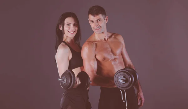 Hombre y mujer atléticos con campanas mudas. Instructor de fitness personal. Entrenamiento personal. Entrenamiento de peso. Entrenamiento . —  Fotos de Stock