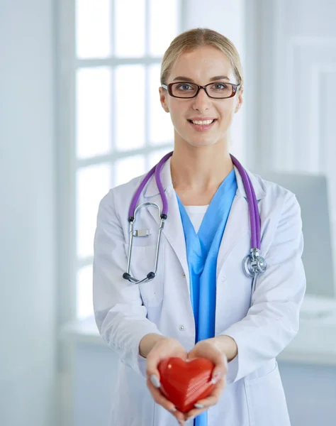 Médico com estetoscópio segurando coração, isolado em fundo branco — Fotografia de Stock