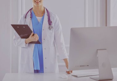 Kadın doktor hastanede dosyayla bekliyor.