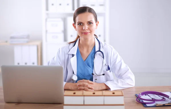 Belle jeune femme médecin souriante assise au bureau et écrivant. femme médecin — Photo