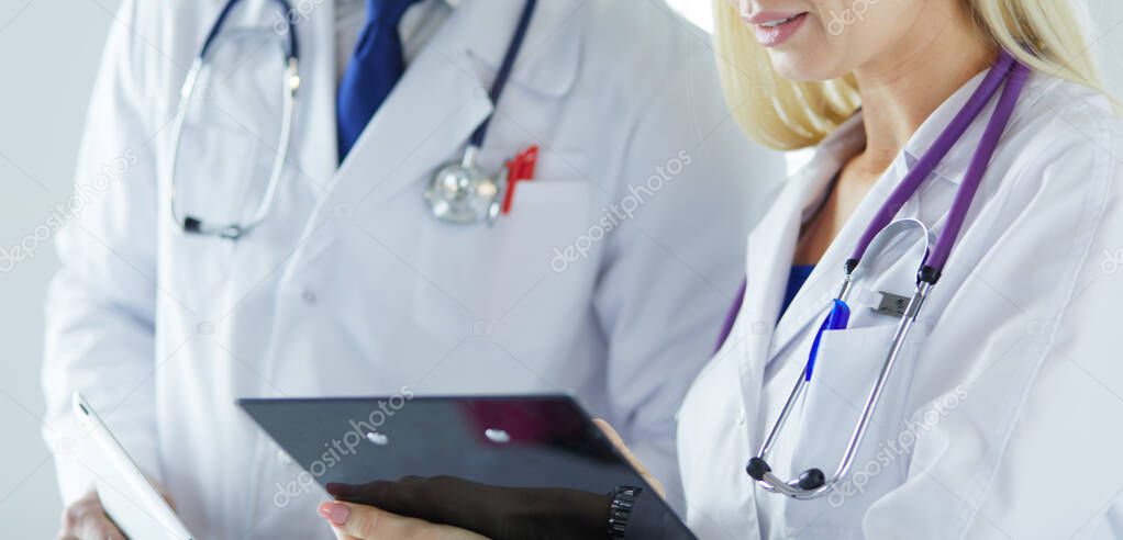 Two doctors holding a folder and talking about patient