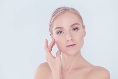 güzel genç kız temiz bir cilt bir el ile bir yanak dokunur.