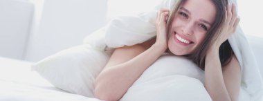 Güzel bir kadın yatağında uzanıyor..