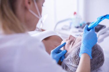 Kaşlar için kalıcı makyaj. Güzellik salonunda kalın kaşlı güzel bir kadın..