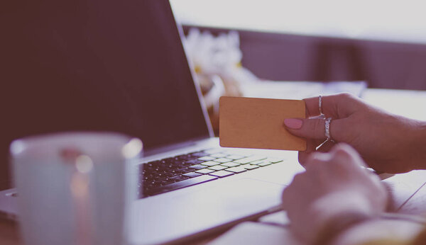 Молодая женщина с кредиткой и ноутбуком. Концепция покупок