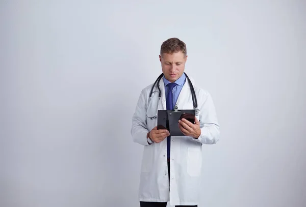 Médico varón de pie con carpeta, aislado sobre fondo blanco —  Fotos de Stock