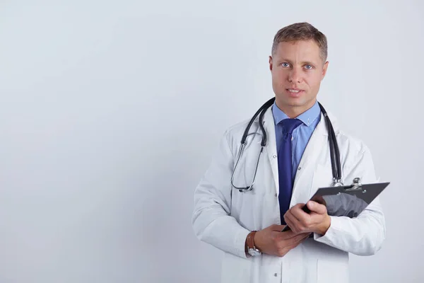 Médico varón de pie con carpeta, aislado sobre fondo blanco — Foto de Stock