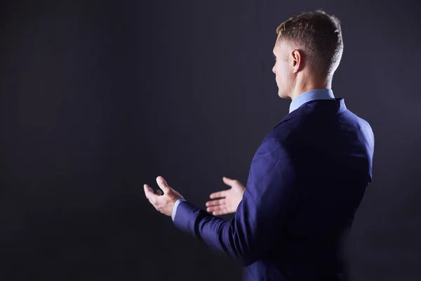 Portrait of a businessman standing with a microphone and looking ahead, speak at the conference — Stock Photo, Image