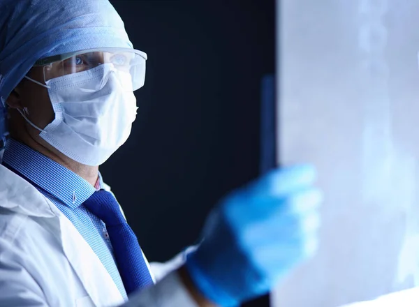 Joven médico buscando imagen de rayos X sobre fondo blanco aislado — Foto de Stock