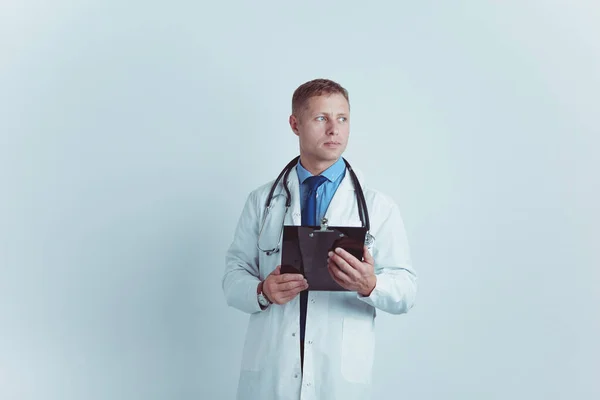 Médico varón de pie con carpeta, aislado sobre fondo blanco — Foto de Stock