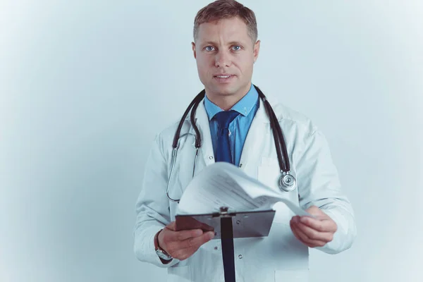 Médecin homme debout avec dossier, isolé sur fond blanc — Photo