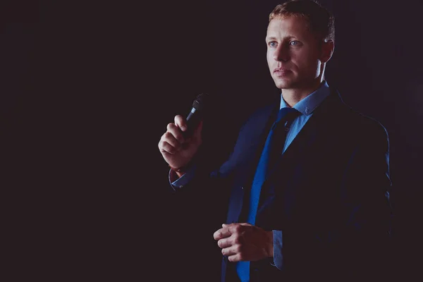 Porträt eines Geschäftsmannes, der mit einem Mikrofon steht und in die Zukunft blickt, spricht auf der Konferenz — Stockfoto