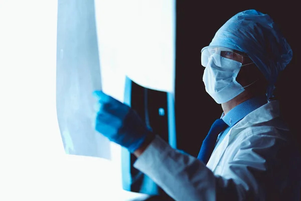 Молодий лікар дивиться рентгенівське зображення на ізольованому білому тлі — стокове фото