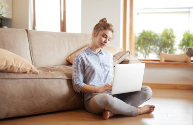oturma odasında yere üstünde laptop ile mutlu bir kadın