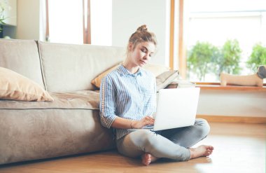 oturma odasında yere üstünde laptop ile mutlu bir kadın