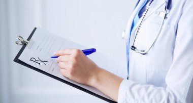 Kadın doktor hastanede dosyayla bekliyor.