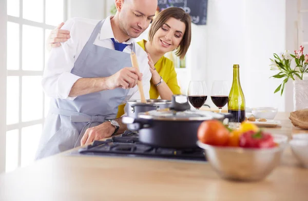 Casal atraente no amor cozinhar e abre o vinho na cozinha, enquanto eles cozinham o jantar para uma noite romântica — Fotografia de Stock