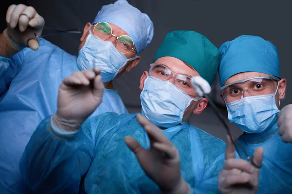 Grupp kirurger i arbete i drift teater tonas i blått. Medicinskt team som utför operationen — Stockfoto