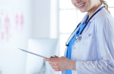 Hastane lobisinde tablet bilgisayar kullanan kadın doktor.