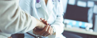 Doktor ya da hemşire yaşlı bayanların elini tutuyor.