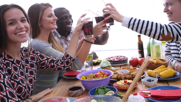 Draufsicht auf eine Gruppe von Menschen beim gemeinsamen Abendessen, während sie am Holztisch sitzen. Essen auf dem Tisch. Menschen essen Fast Food. — Stockfoto