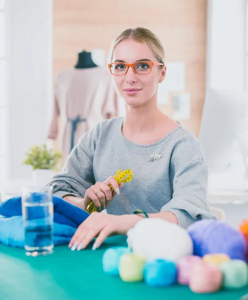 Design de moda trabalhando em estúdio sentado na mesa — Fotografia de Stock