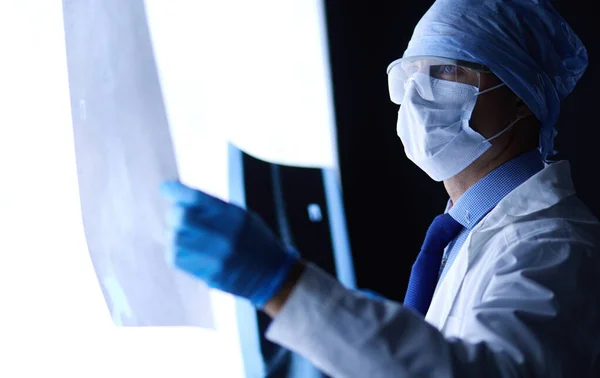 Joven médico buscando imagen de rayos X sobre fondo blanco aislado — Foto de Stock