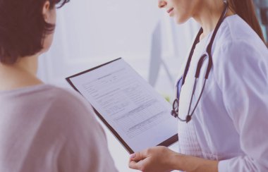 Güzel bayan doktor bir hastaya tıbbi tedaviyi açıklıyor.