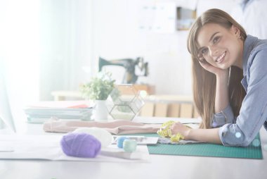 moda tasarımcısı olarak stüdyonun tasarımları üzerinde çalışıyor