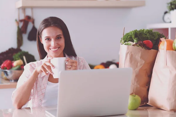 Lächelnde Frau beim Online-Shopping mit Tablet und Kreditkarte in der Küche. Lächelnde Frau — Stockfoto