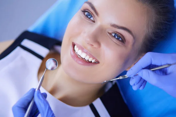 Молода пацієнтка з гарненькою посмішкою оглядає стоматологічний огляд в стоматологічному кабінеті . — стокове фото