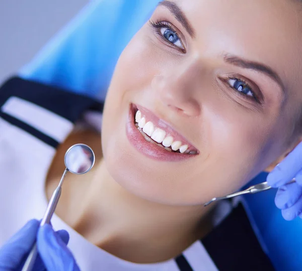 Νεαρή γυναίκα ασθενής με όμορφο χαμόγελο που εξετάζει την οδοντιατρική εξέταση στο οδοντιατρείο. — Φωτογραφία Αρχείου