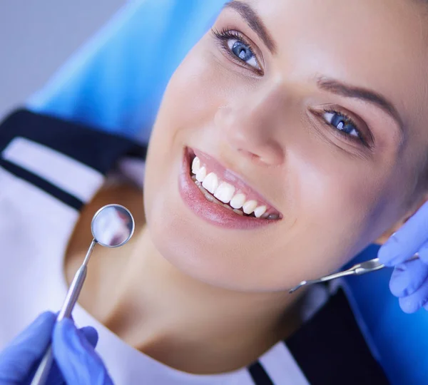 Joven paciente femenina con sonrisa bonita examinando la inspección dental en el consultorio del dentista. — Foto de Stock