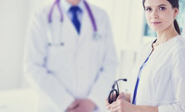 İki doktor hastanedeki konferans odasında, biri kameraya bakıyor.