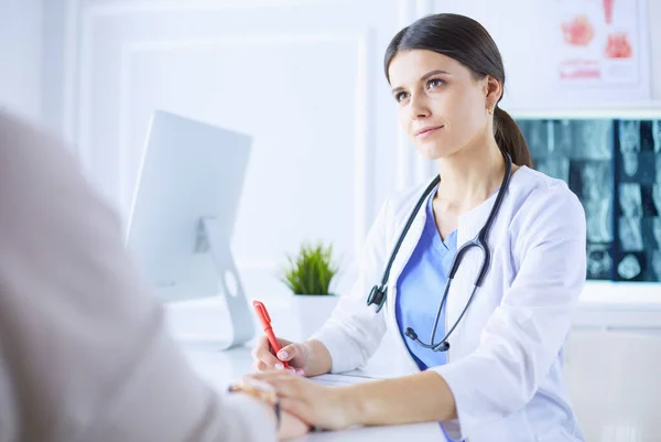 Medico femminile calmare una paziente in una sala di consulenza ospedaliera, tenendole la mano — Foto Stock