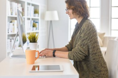 Evde tablet bilgisayar kullanan genç bir kadın ya da öğrenci