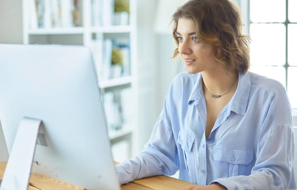 Söt ung kvinna sitter vid skrivbordet och skriver på laptop — Stockfoto