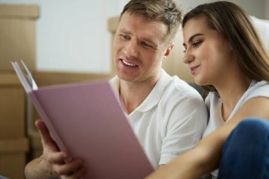 Yeni evlerinde karton kutuları açan sevimli bir çift.