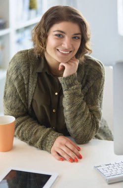 Öğrenci laptopla çalışıyor ve evdeki masada oturuyor.