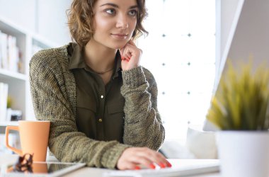 Dizüstü bilgisayarda eğitim kursuna bakan genç bir kadın.