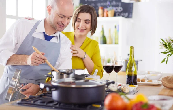 Casal atraente no amor cozinhar e abre o vinho na cozinha, enquanto eles cozinham o jantar para uma noite romântica — Fotografia de Stock