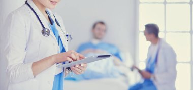 Hastane lobisinde tablet bilgisayar kullanan kadın doktor.