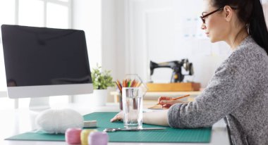 Moda tasarımcısının stüdyosunda çalışan portresi.