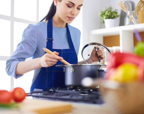 Mujer cocinera en cocina con cuchara de madera — Foto de Stock