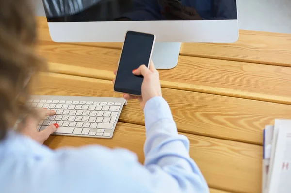 Mulher feliz trabalhando usando vários dispositivos em uma mesa em casa — Fotografia de Stock