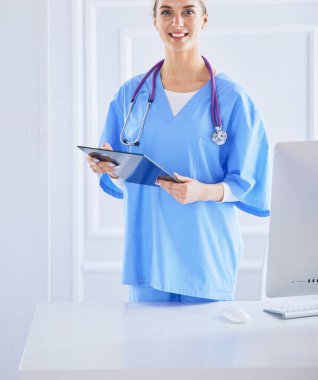 Üniformalı bir dosyayla gülümseyen kadın doktor