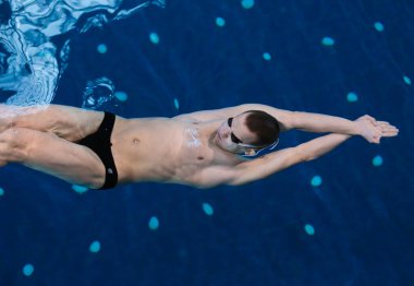 Yüzme havuzunda erkek yüzücü. Su altı fotoğrafı. Erkek yüzücü.